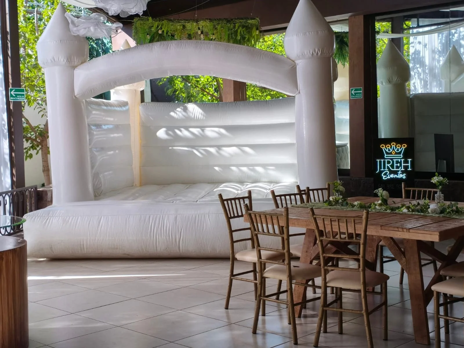 Brincolín blanco premium instalado en un evento